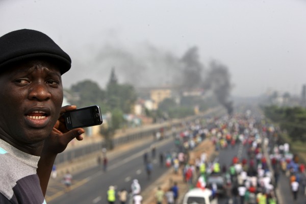 A protester uses his mobile phone to take photos of demonstrators protesting against the removal of a popular fuel subsidy by the Nigerian government.